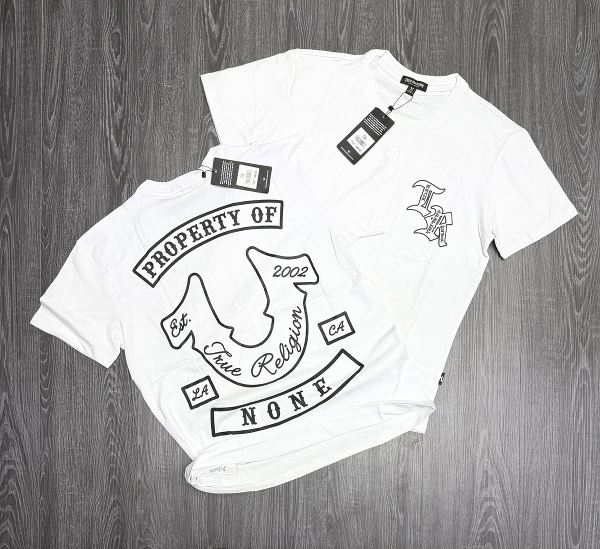 Foto original de playera blanca con monograma frontal y herradura negra en la espalda