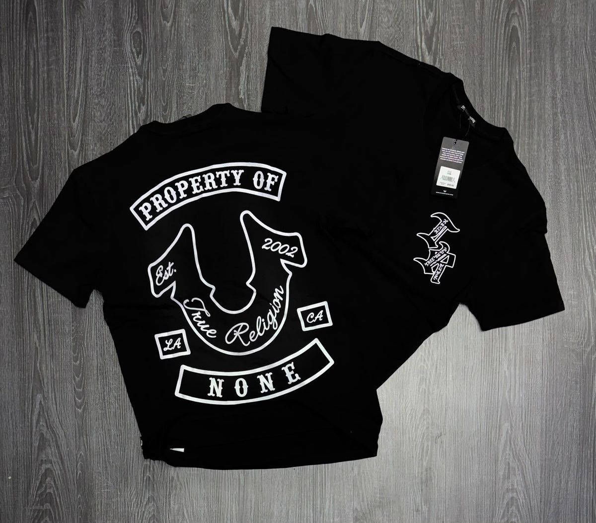 Foto original de playera negra con monograma blanco frontal y herradura en la espalda